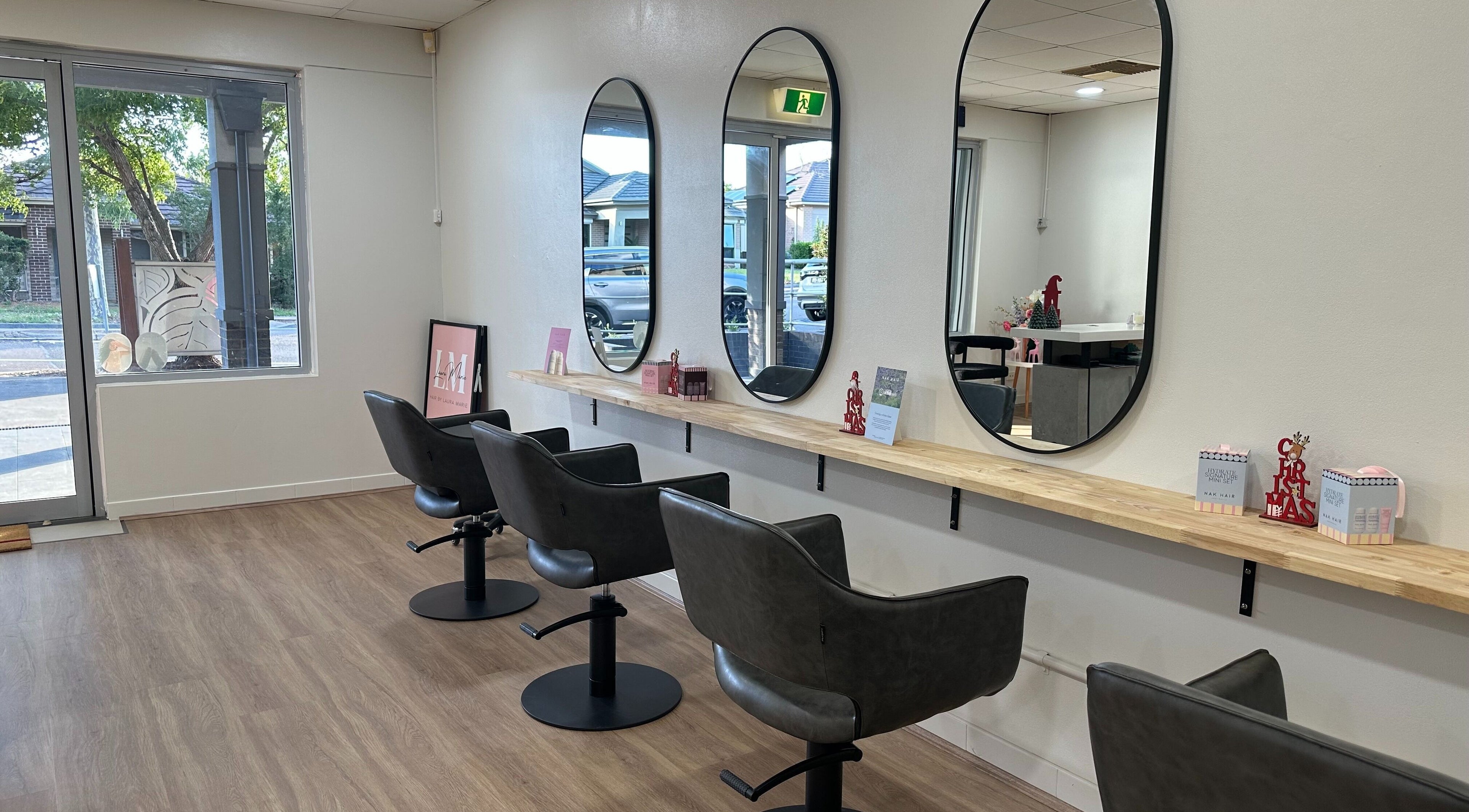 Stylish salon interior at Hair by Laura Marie, Mount Annan, New South Wales, AU with modern chairs and mirrors.