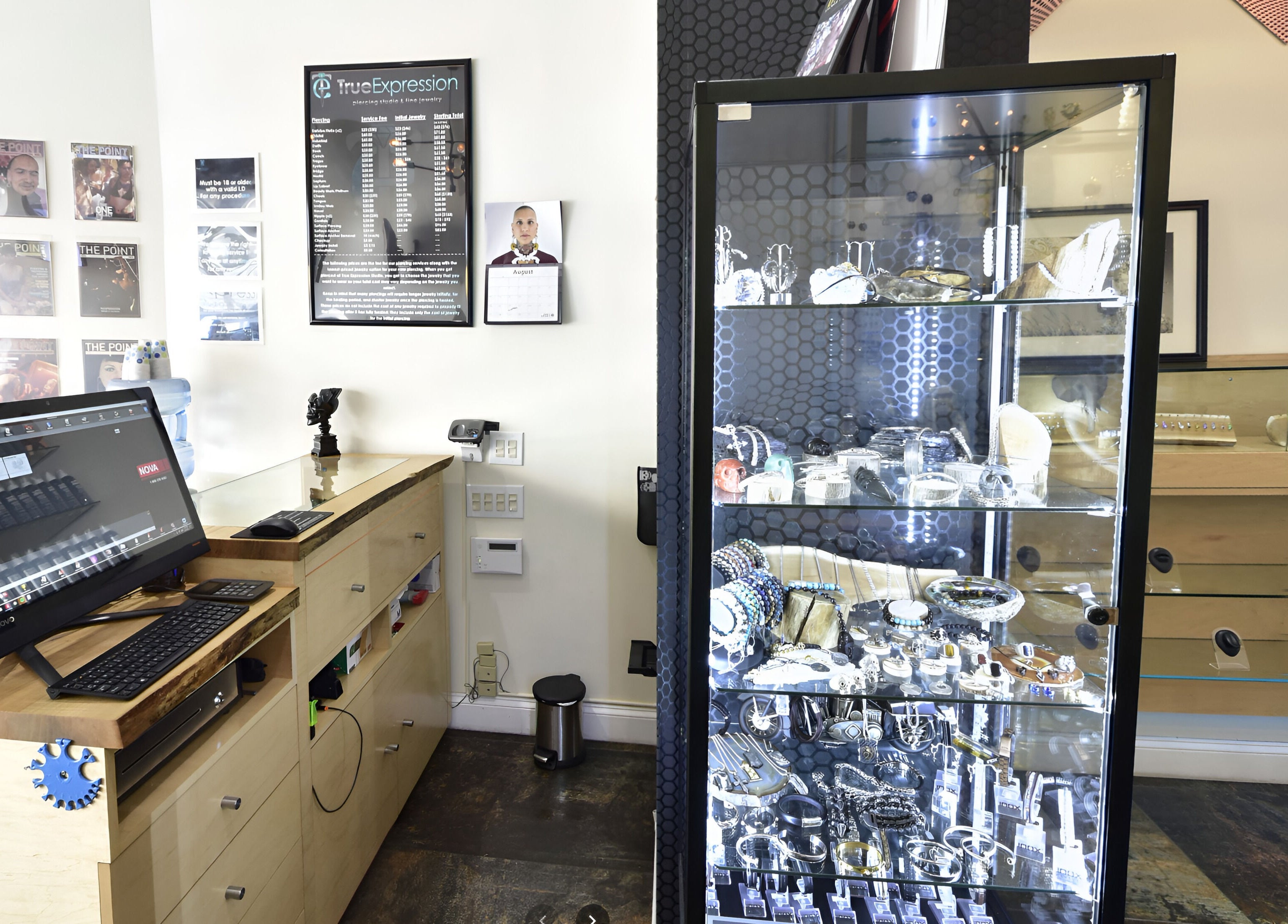 Reception at True Expression Piercing Studio, New York, showcasing jewelry in a glass display.
