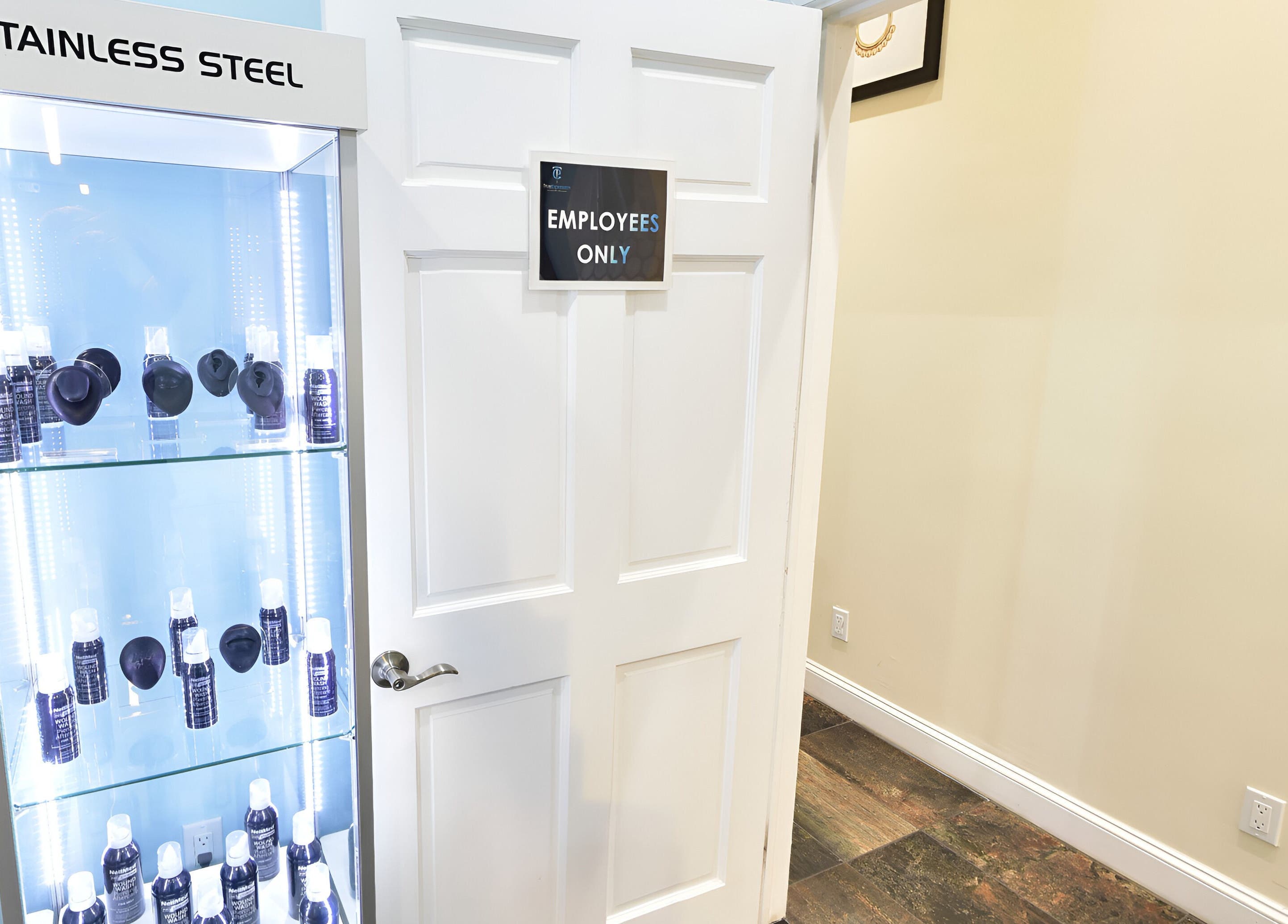 Glass display at True Expression Piercing Studio, New York, New York, US with products and employees-only door.
