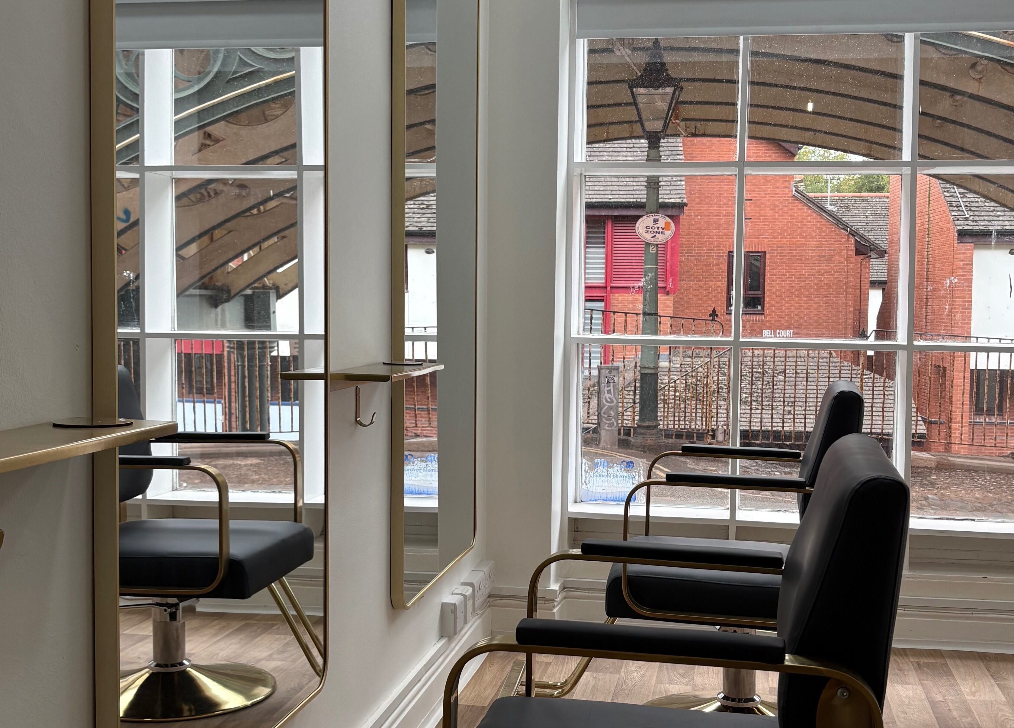 Elegant salon chairs at 14a Lower North Street, Exeter, England, GB with large windows and bright interior.
