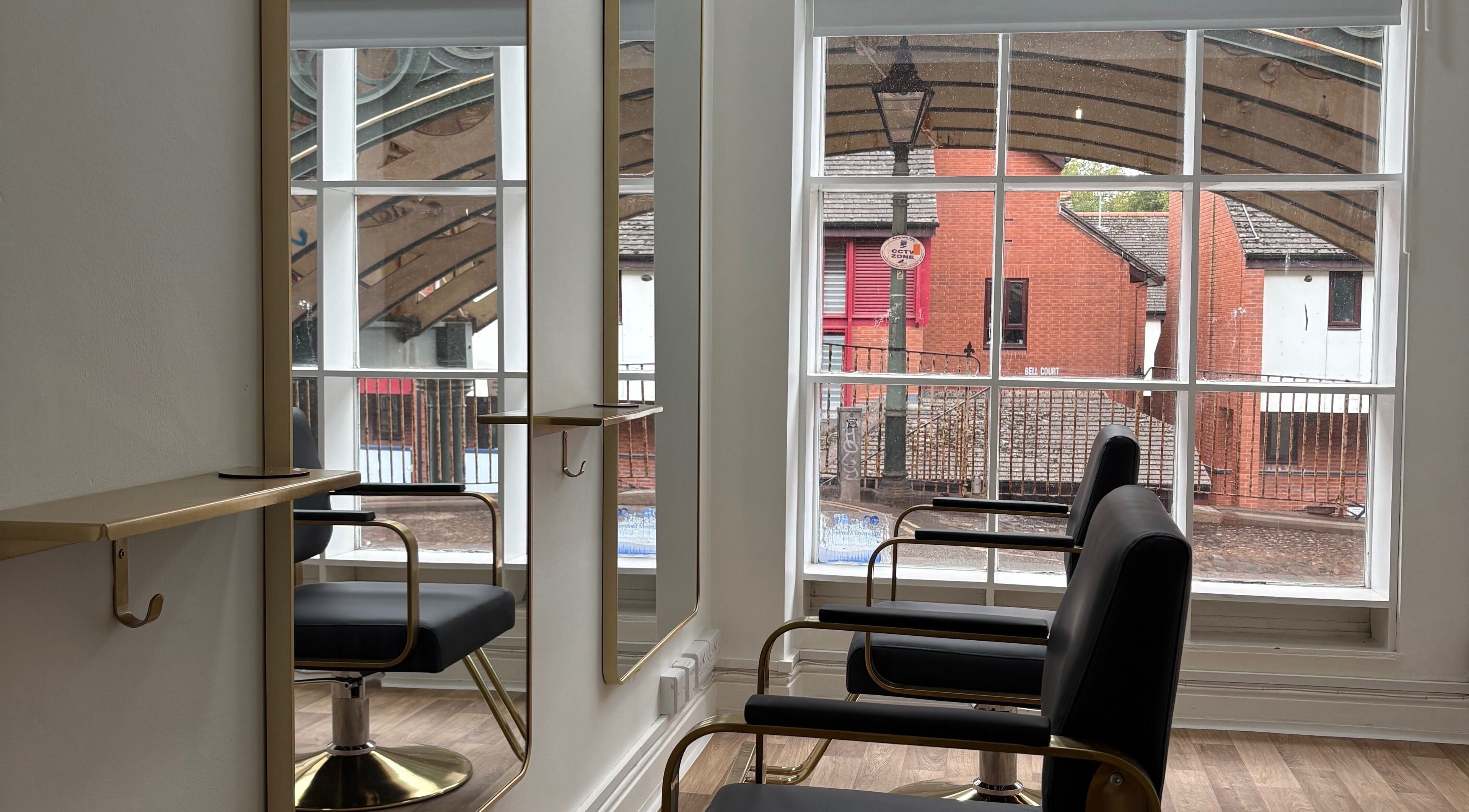 Elegant salon chairs at 14a Lower North Street, Exeter, England, GB with large windows and bright interior.
