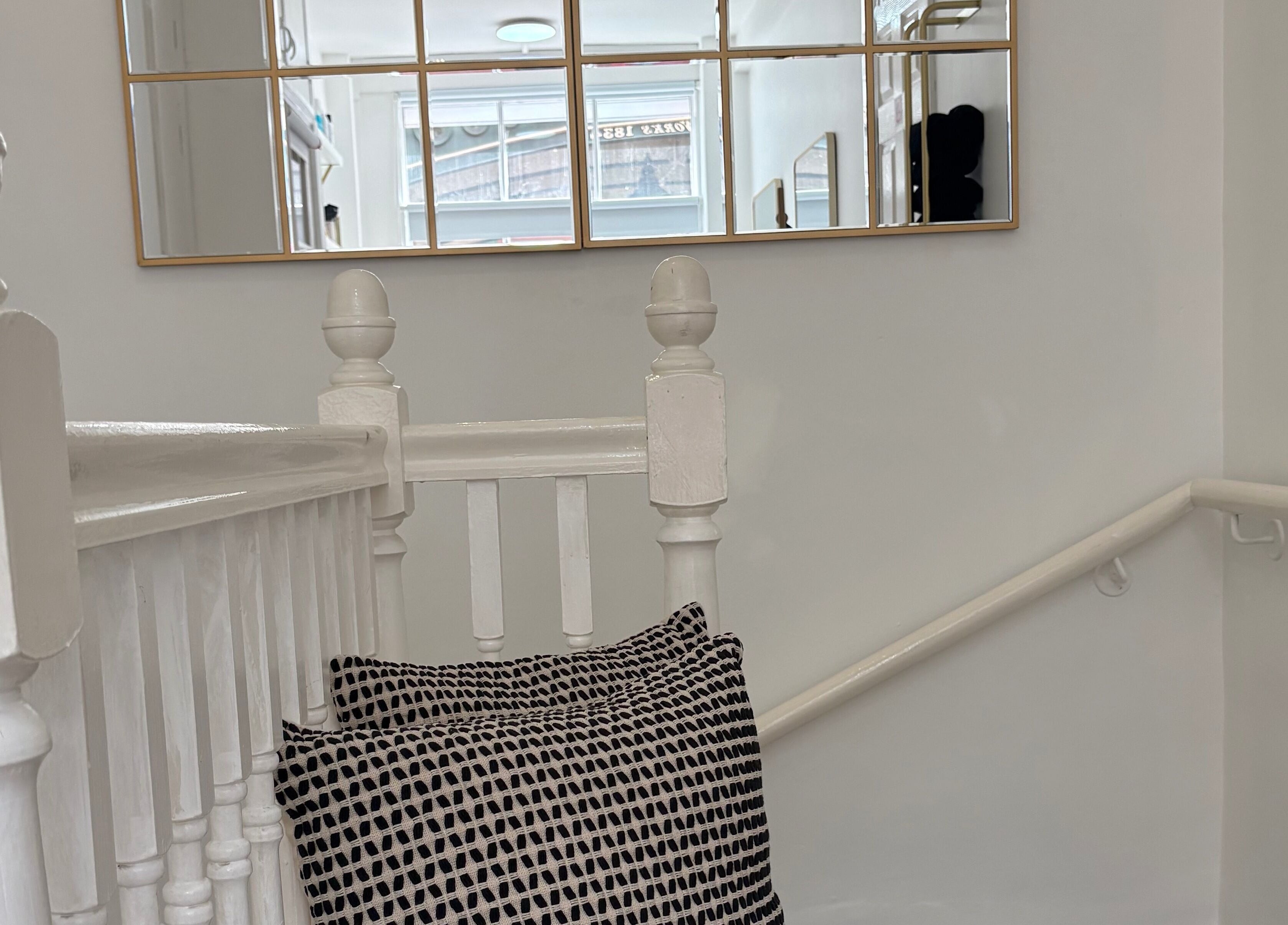 Elegant stairway with mirror and cushion at 14a Lower North Street, Exeter, England, GB.