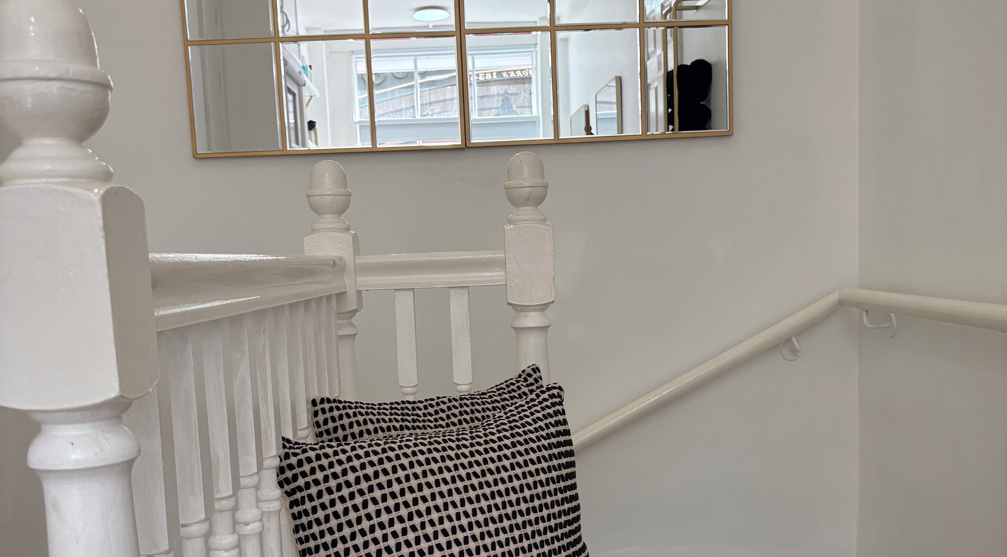 Elegant stairway with mirror and cushion at 14a Lower North Street, Exeter, England, GB.