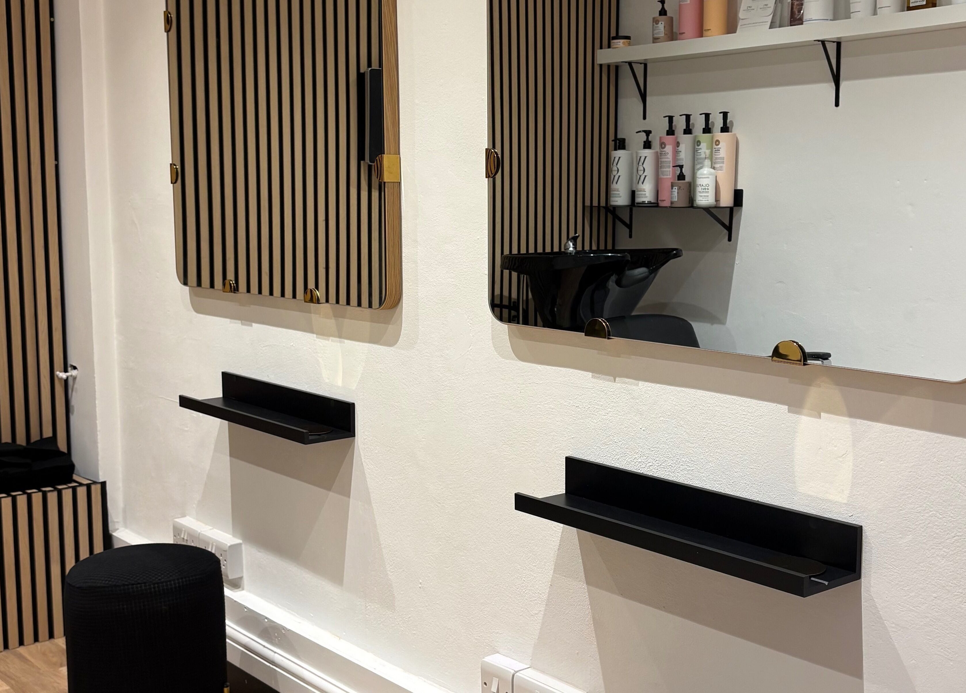 Modern salon station at 14a Lower North Street, Exeter, England, GB with sleek mirrors and beauty products.
