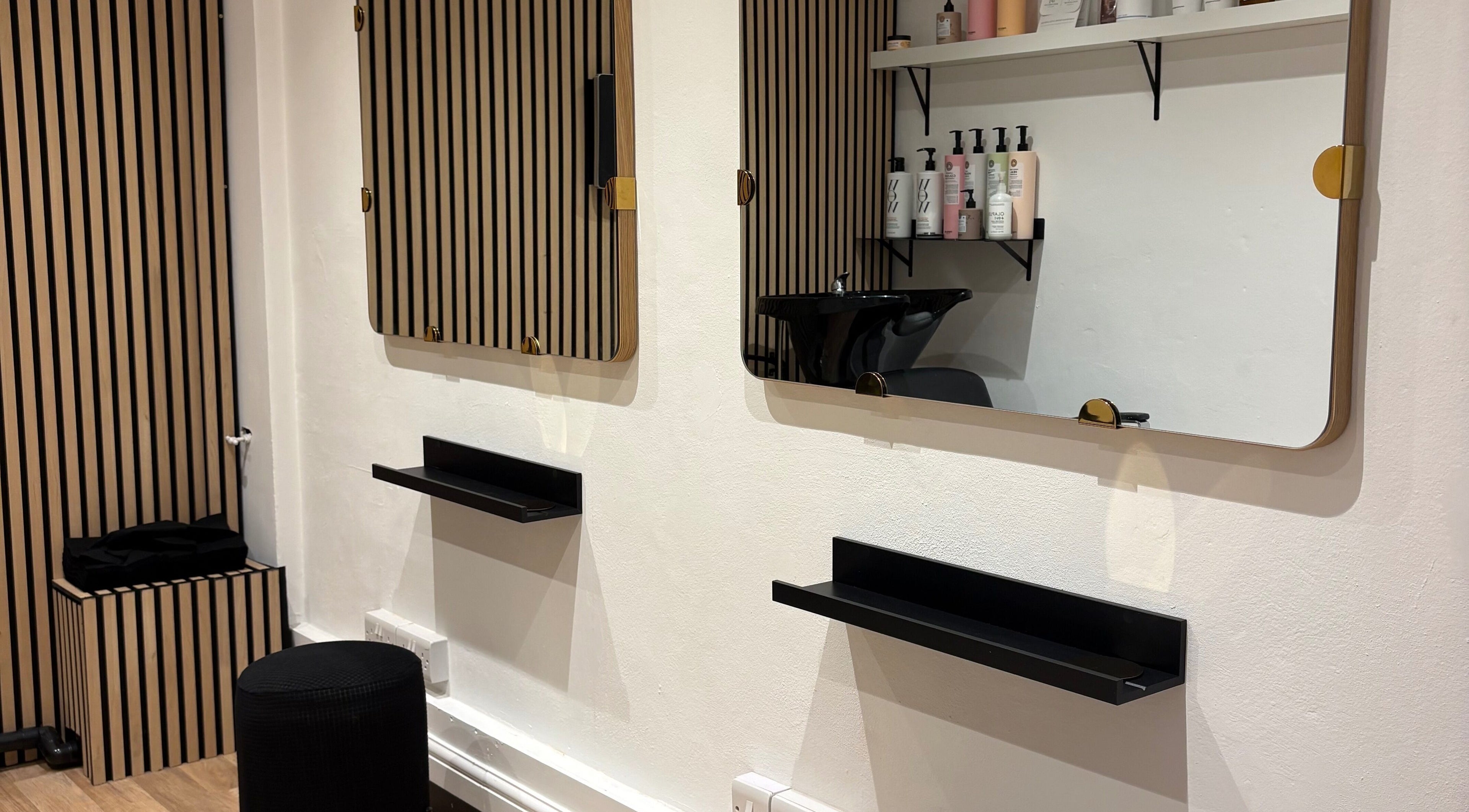 Modern salon station at 14a Lower North Street, Exeter, England, GB with sleek mirrors and beauty products.