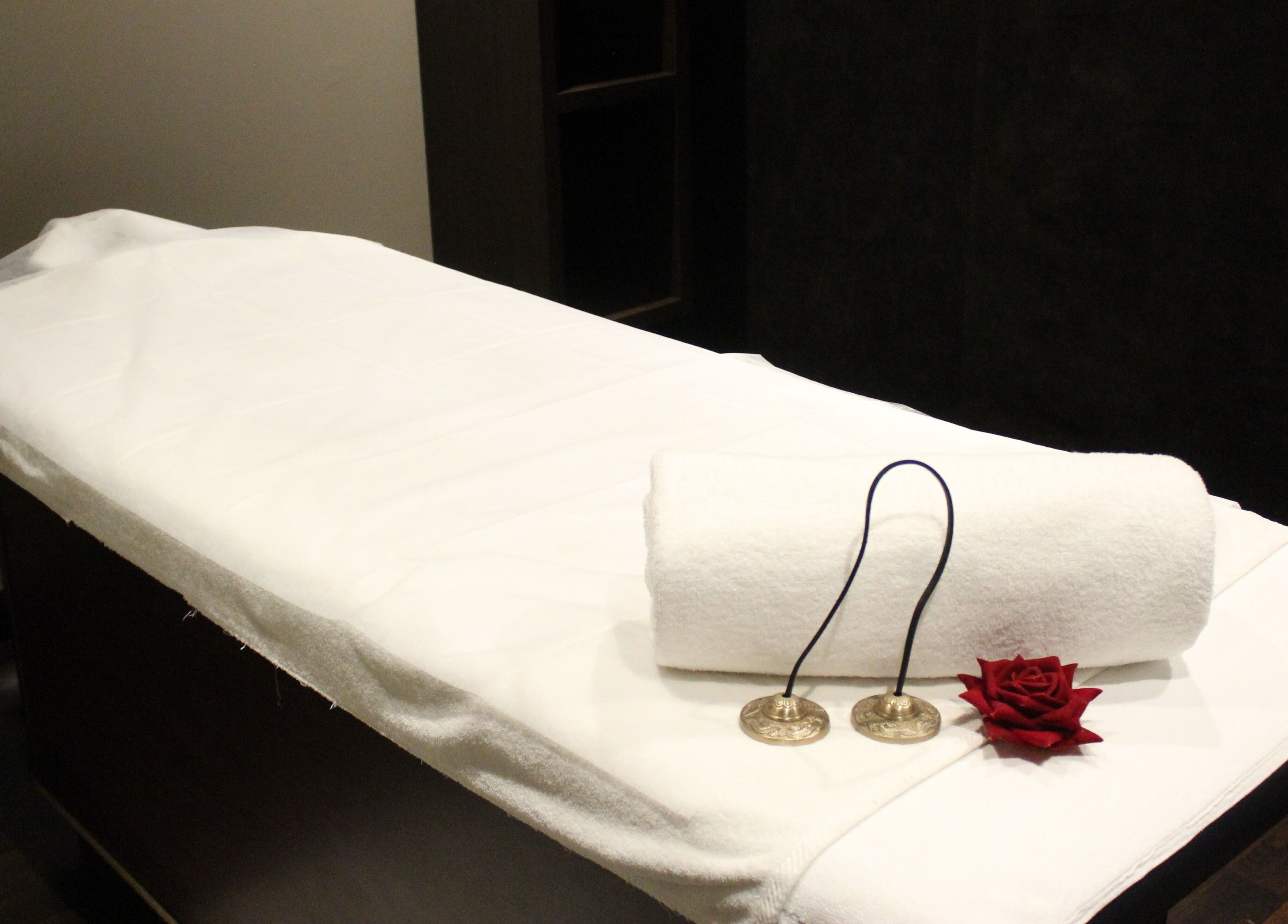 Massage table set with white linen and decor at DWS-Palm Jumeirah, Dubai, AE, offering a serene wellness experience.
