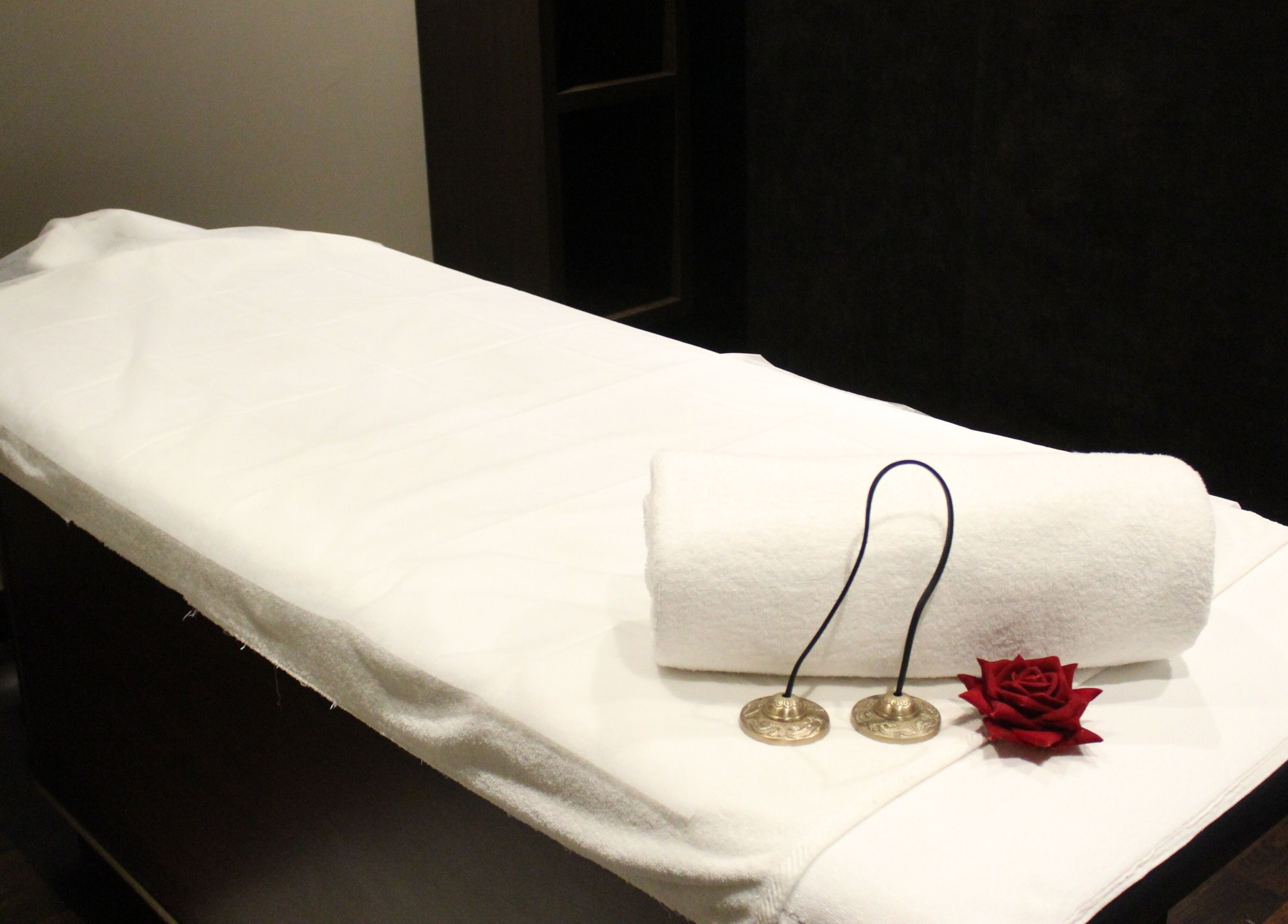 Massage table set with white linen and decor at DWS-Palm Jumeirah, Dubai, AE, offering a serene wellness experience.