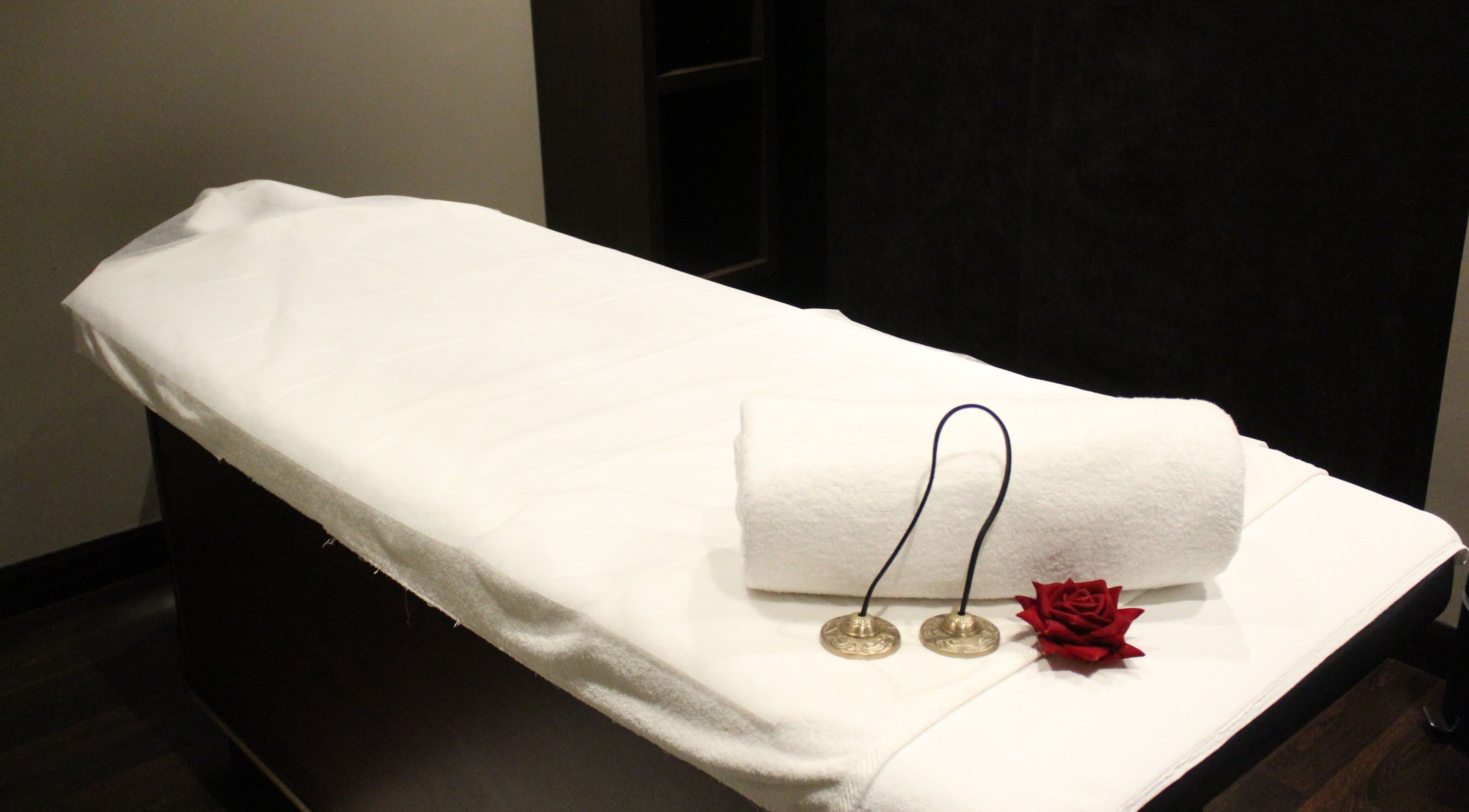 Massage table set with white linen and decor at DWS-Palm Jumeirah, Dubai, AE, offering a serene wellness experience.