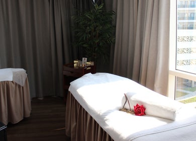 Luxurious massage room at DWS-Radisson Canal View, Dubai, Dubai, AE with soft lighting and plush treatment table.