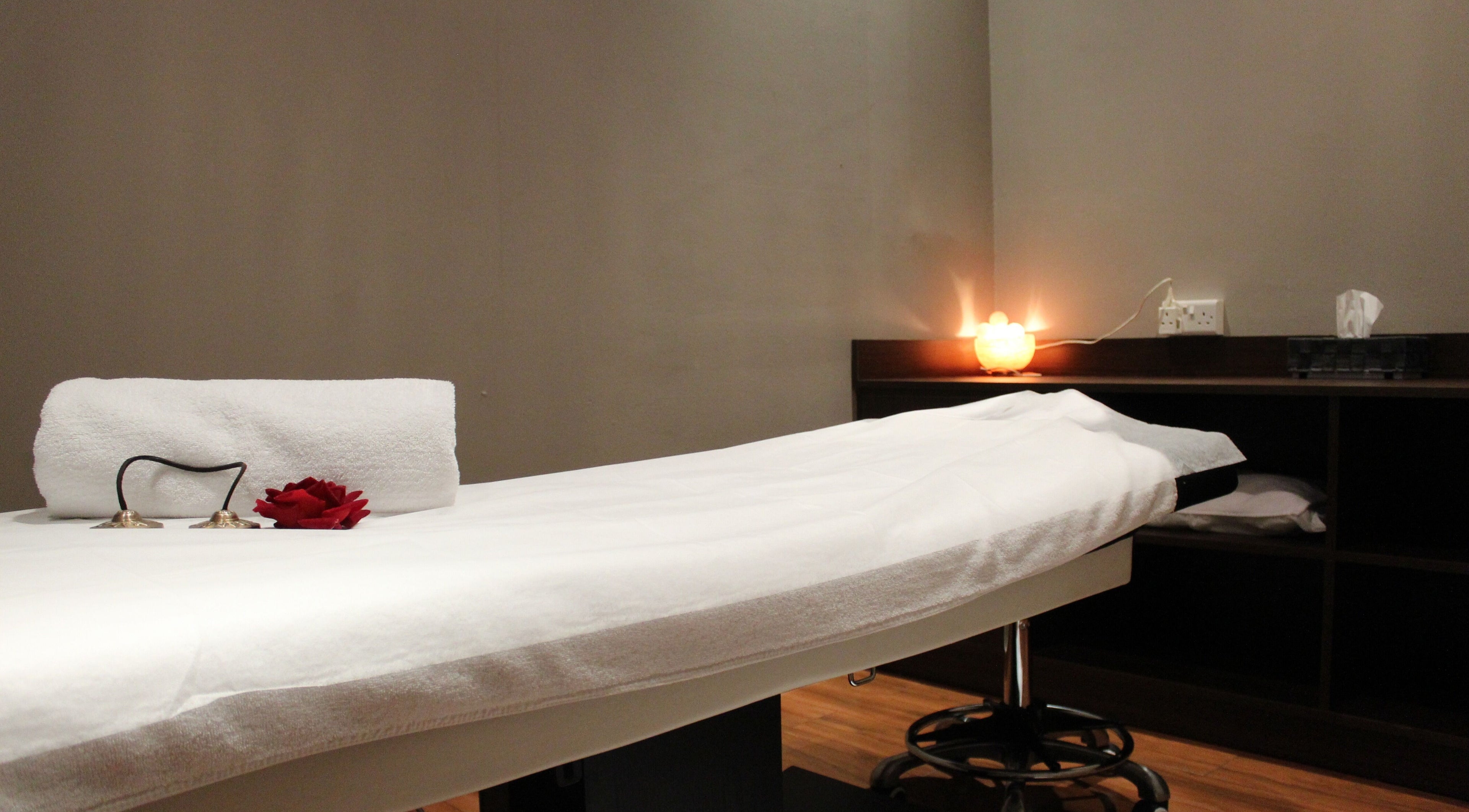 Relaxing spa treatment room at DWS-Marina Cascades, Dubai, Dubai, AE with ambient lighting and a massage table.