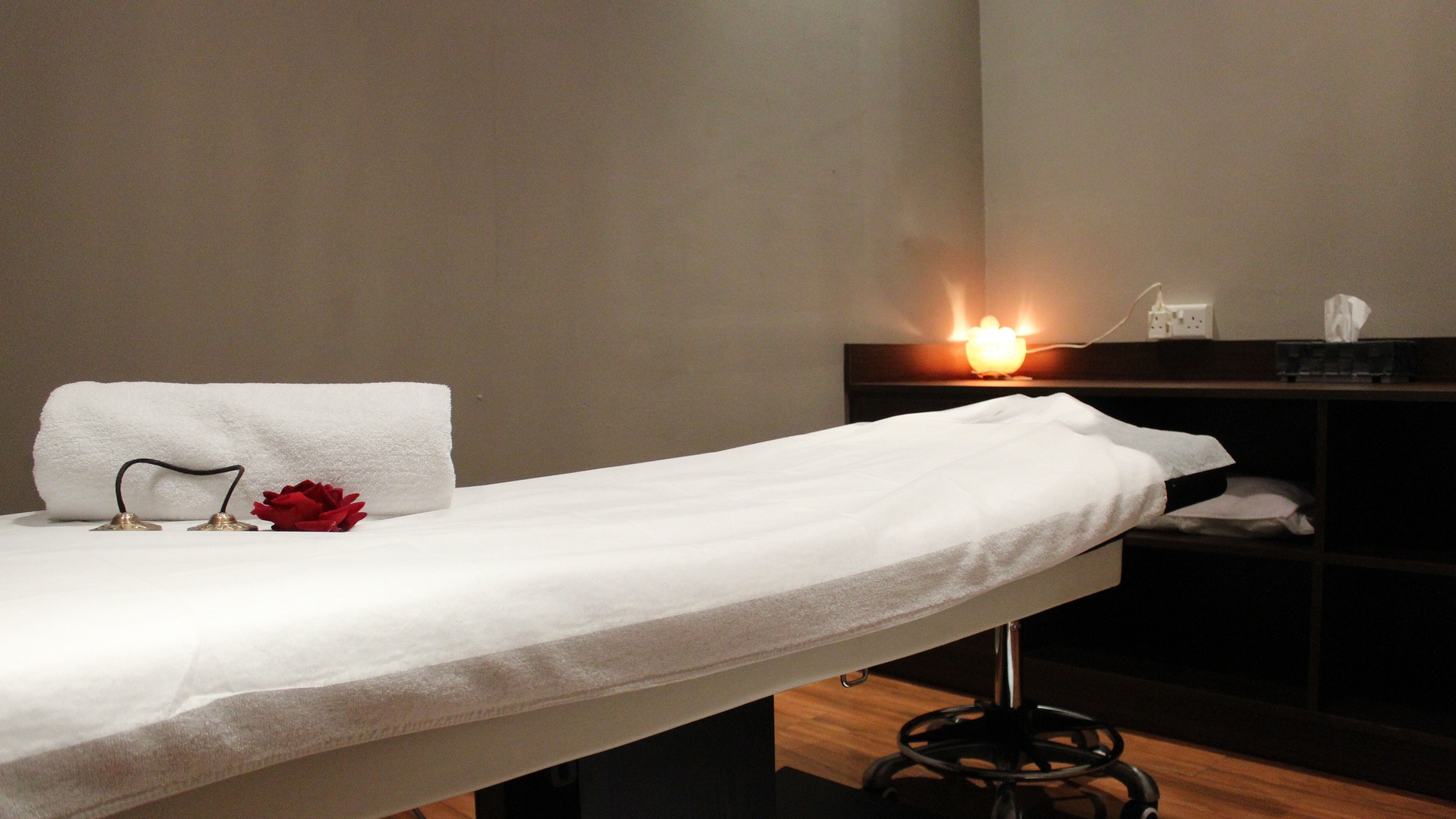Relaxing spa treatment room at DWS-Marina Cascades, Dubai, Dubai, AE with ambient lighting and a massage table.