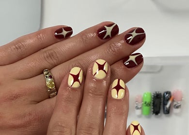 Stylish star-themed nail art at Suki Nailz, London, England, GB showcases intricate design and vibrant colors.