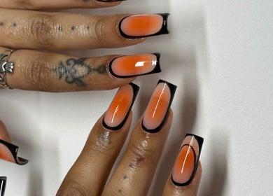 Stylish nail art with orange and black design at Suki Nailz, London, England, GB.