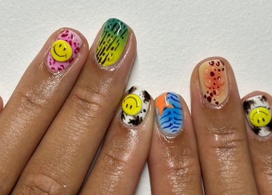 Colorful nail art at Suki Nailz, London, England, GB showcasing unique designs and smiley accents.