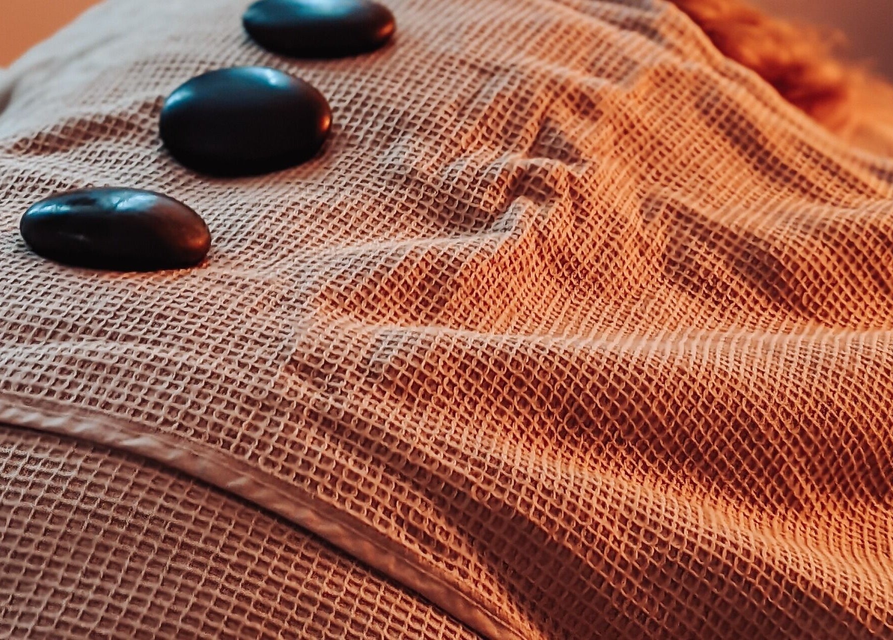 Hot stones on a massage table at Louise Palmer Holistics, Southampton, England, GB for ultimate relaxation.