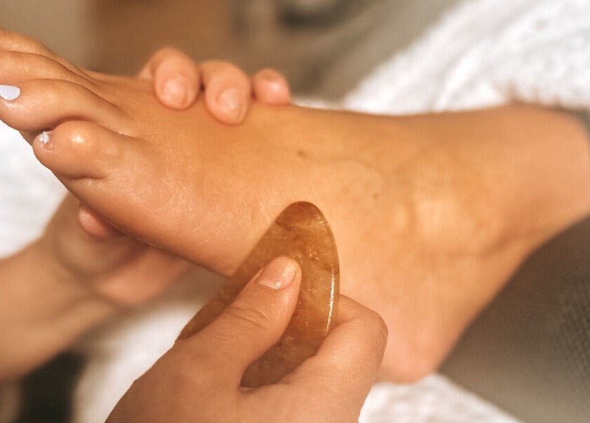 Foot receiving relaxing gua sha treatment at Louise Palmer Holistics, Southampton, England, GB.