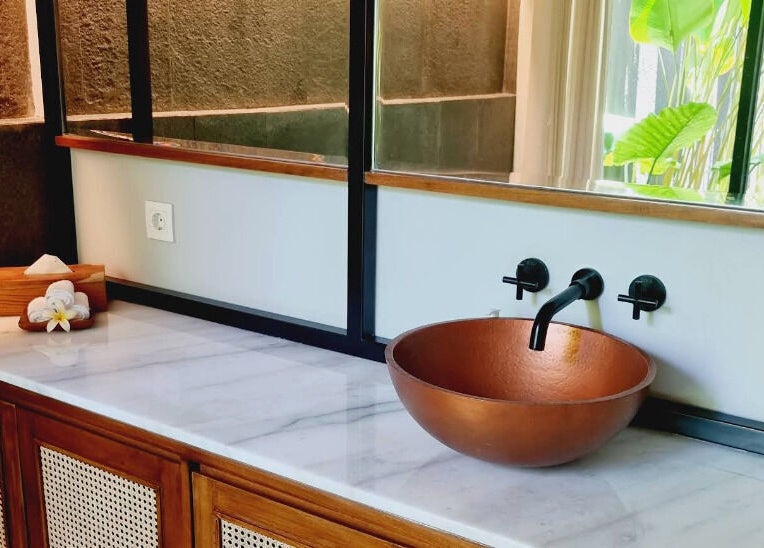 Elegant copper sink and marble counter at Ame Spa Bali, Bali, ID with natural lighting and serene ambiance.