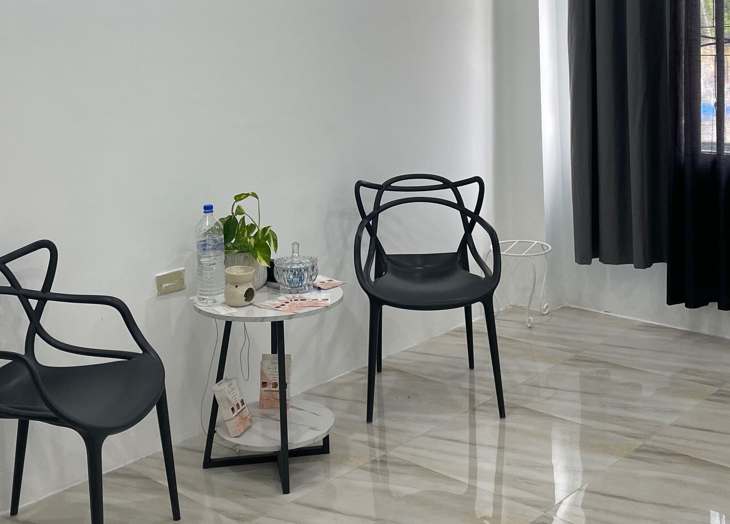 Modern seating area at Jahzeni Beauty Lounge, Runaway Bay, St. Ann Parish, JM with stylish black chairs and a small table.