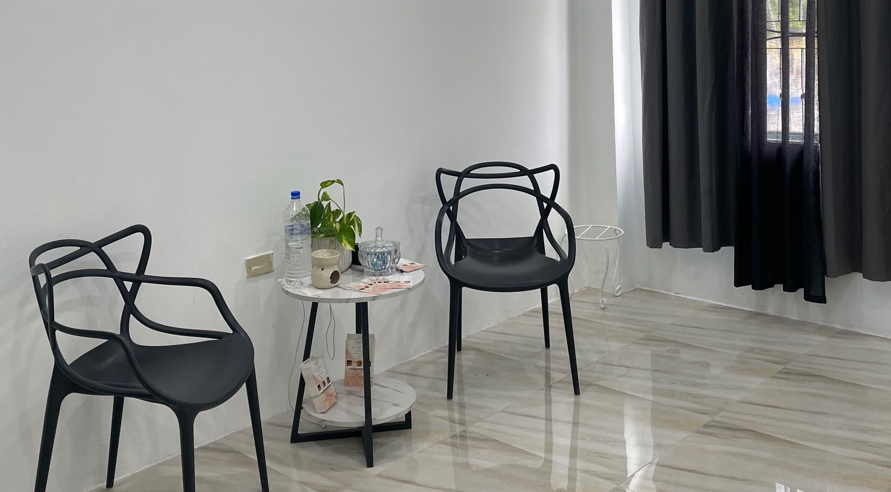 Modern seating area at Jahzeni Beauty Lounge, Runaway Bay, St. Ann Parish, JM with stylish black chairs and a small table.