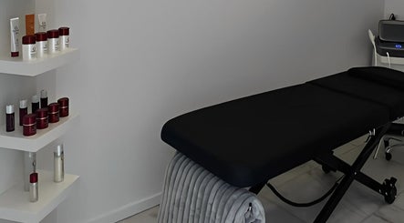 Treatment room at Cosmo Medispa, Ramsgate, New South Wales, AU featuring a massage table and skincare products on shelves.