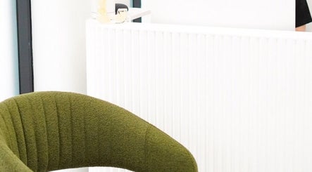 Elegant reception area with green chair at Cosmo Medispa, Ramsgate, New South Wales, AU.