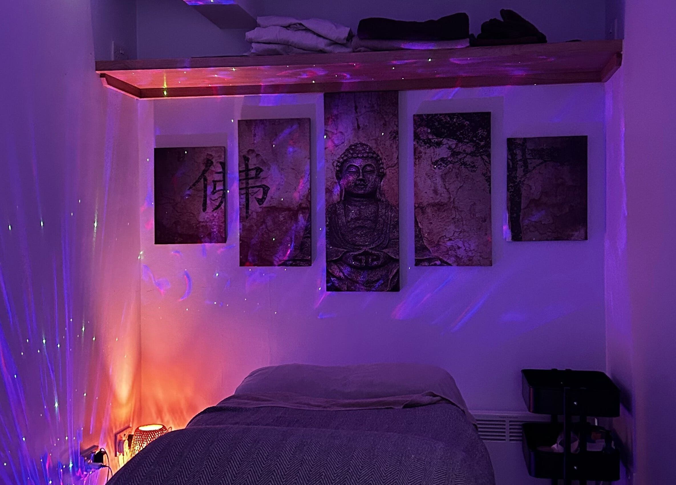 Serene massage room at The Soul Sanctuary, Garstang, England, GB with calming purple lighting.