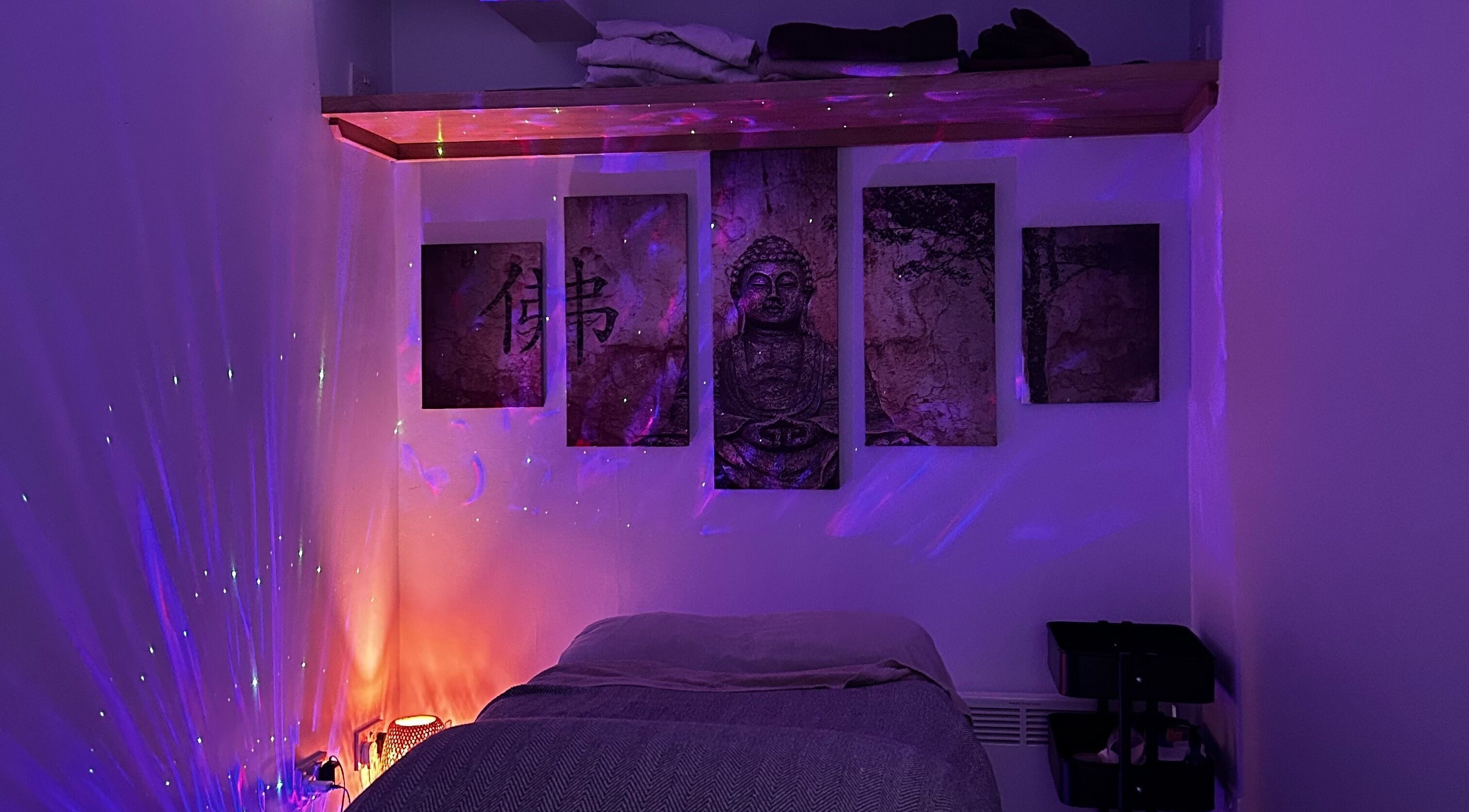 Serene massage room at The Soul Sanctuary, Garstang, England, GB with calming purple lighting.