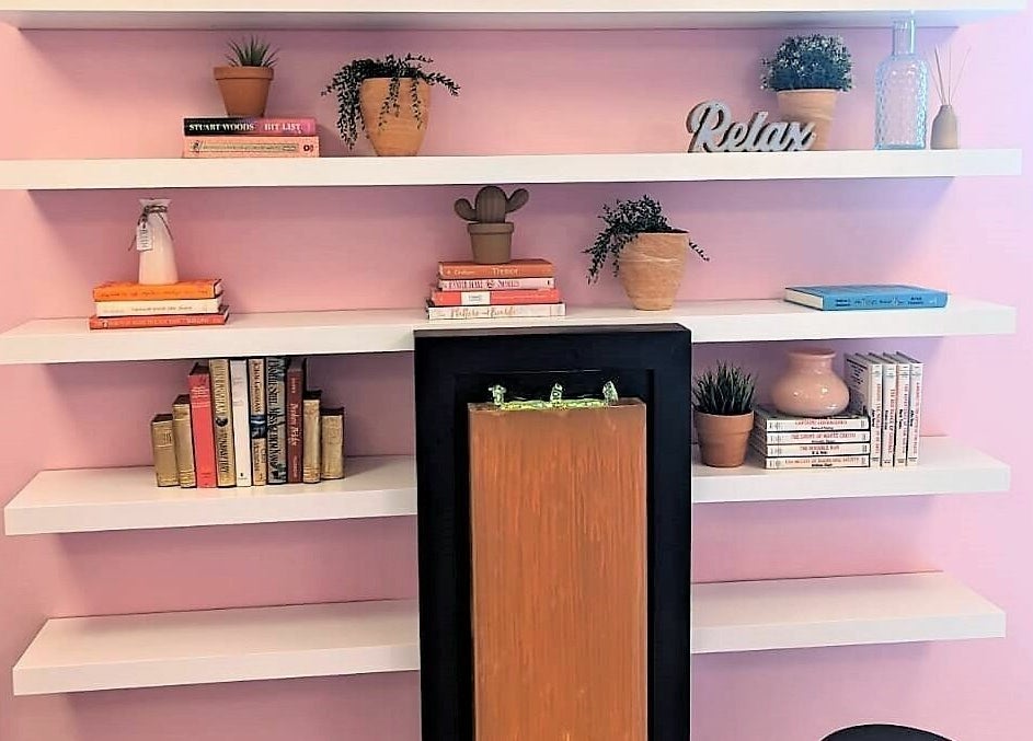Elegant pink-accented bookshelf in Tropical Touch Polaris, Columbus, Ohio, US, with decor and wellness ambiance.