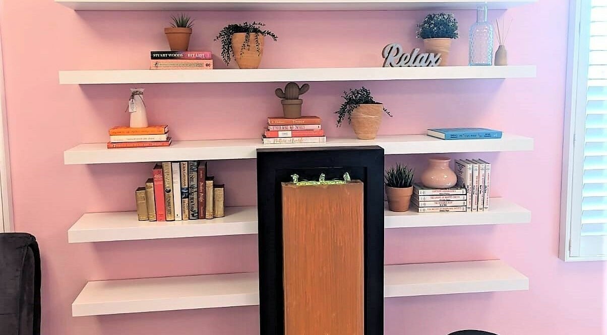 Elegant pink-accented bookshelf in Tropical Touch Polaris, Columbus, Ohio, US, with decor and wellness ambiance.