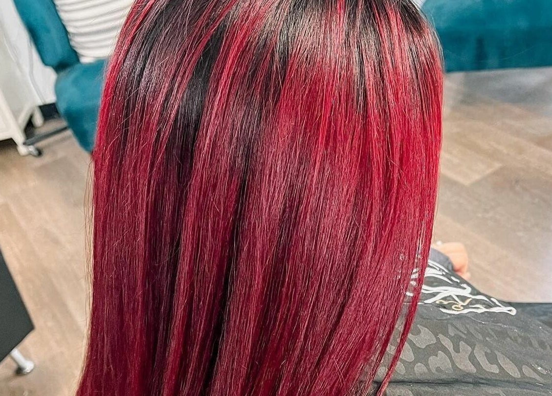 Vibrant red hair styled at JEM Luxe Salon LLC, Coloma, Michigan, US. Sophisticated and modern salon setting.