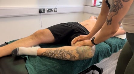 Therapist massages tattooed leg at High Pavement House, Sutton-in-Ashfield, England, GB.