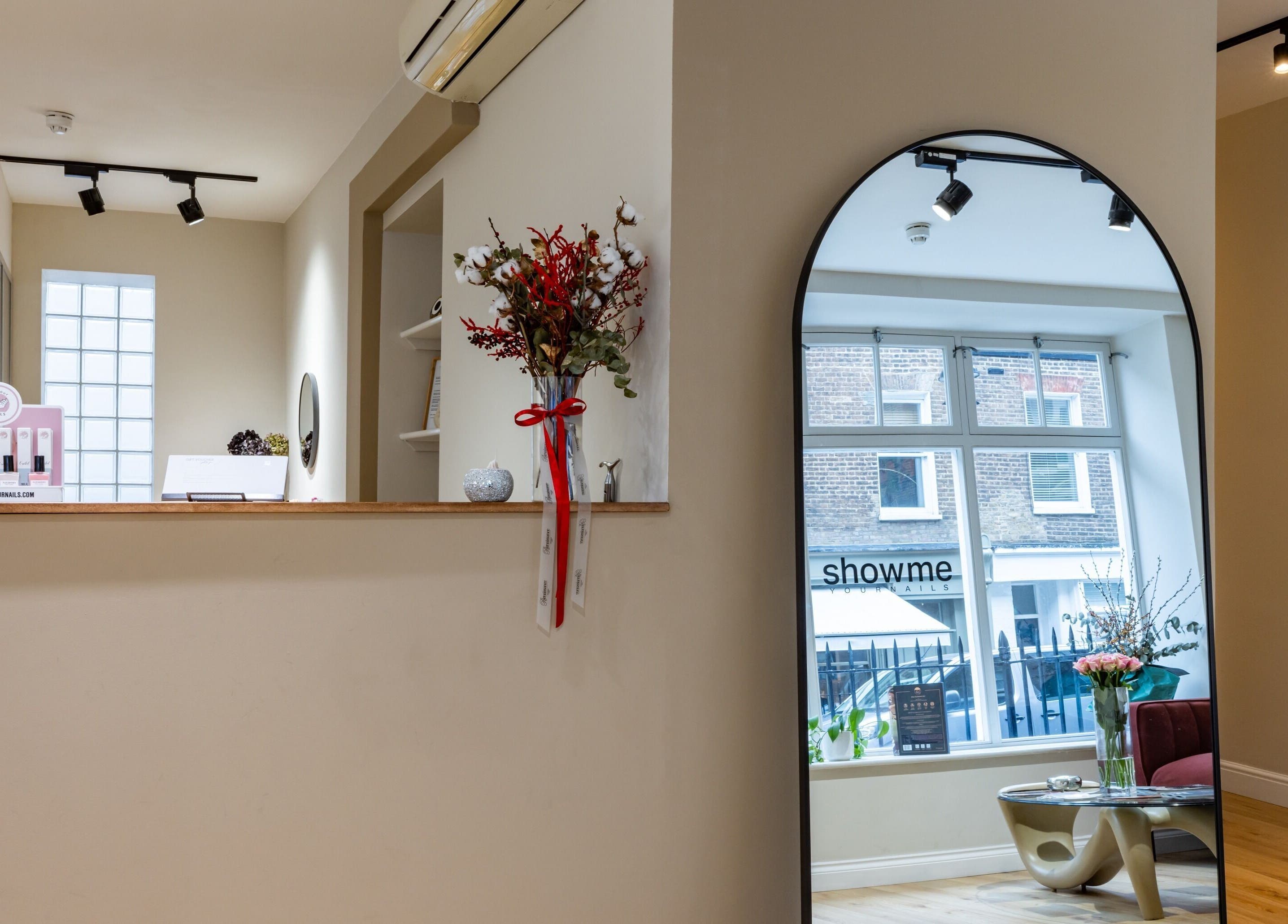 Chic interior of Show Me Your Nails in London, England, GB with stylish decor and floral arrangements.