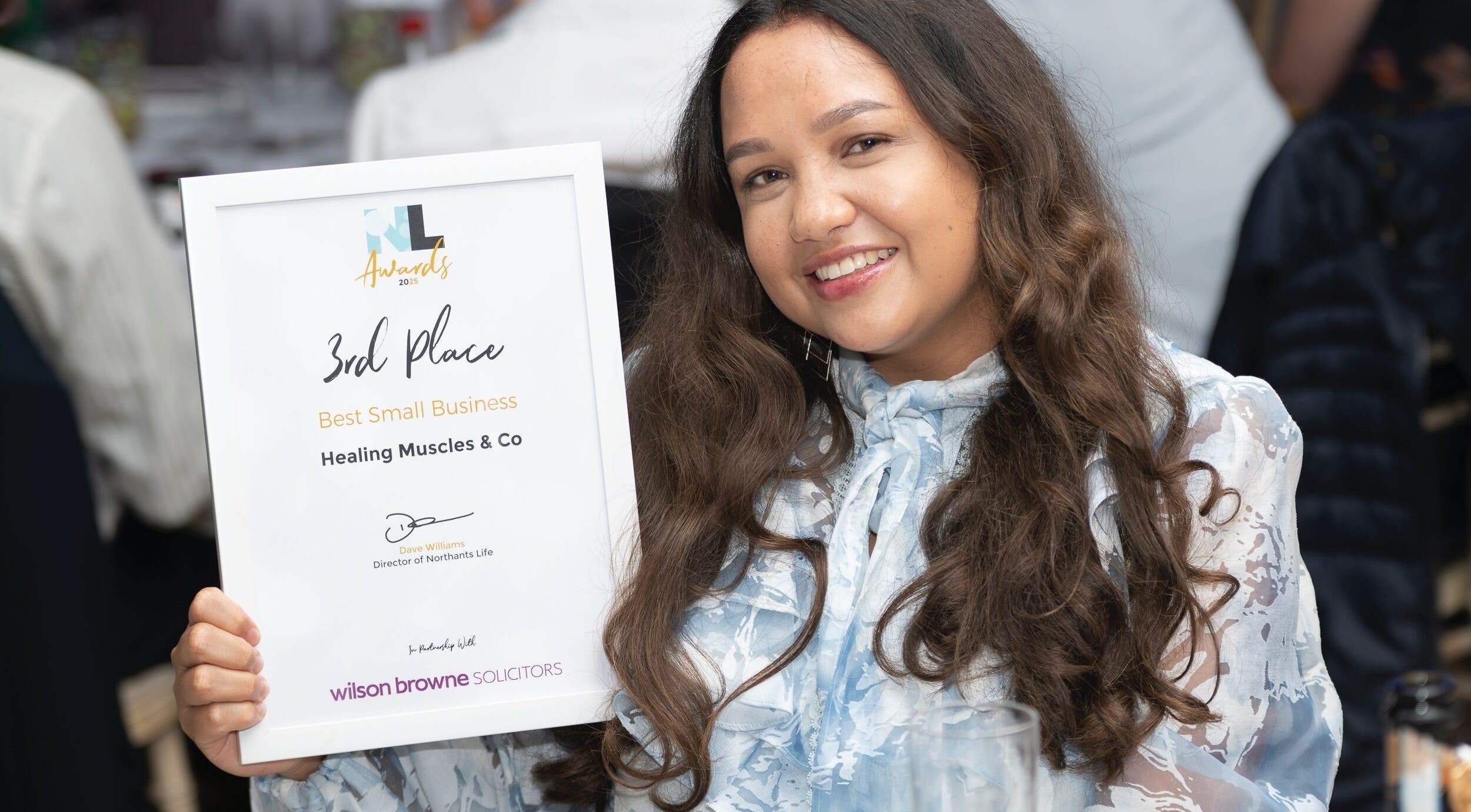 Healing Muscles Northampton wins award in Overstone, England, GB. Smiling woman with certificate in hand.