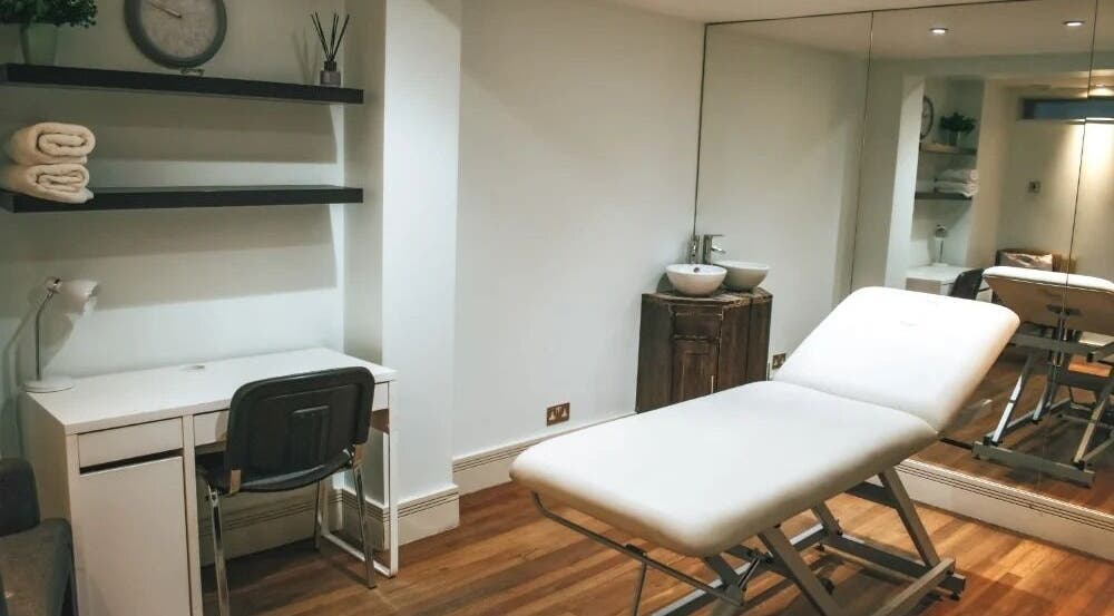 Modern treatment room at Avena Clinic - Dr Hen in London, England, GB, featuring a massage table and minimalist decor.