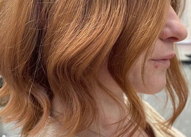 Side view of a woman's chic auburn hairstyle at Beauty From The Heart, Belper, England, GB.