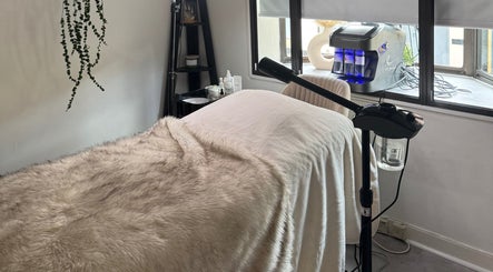 Cozy treatment room at Alexandra Beauty, Norwich, England, GB, featuring soft fur throws and modern equipment.