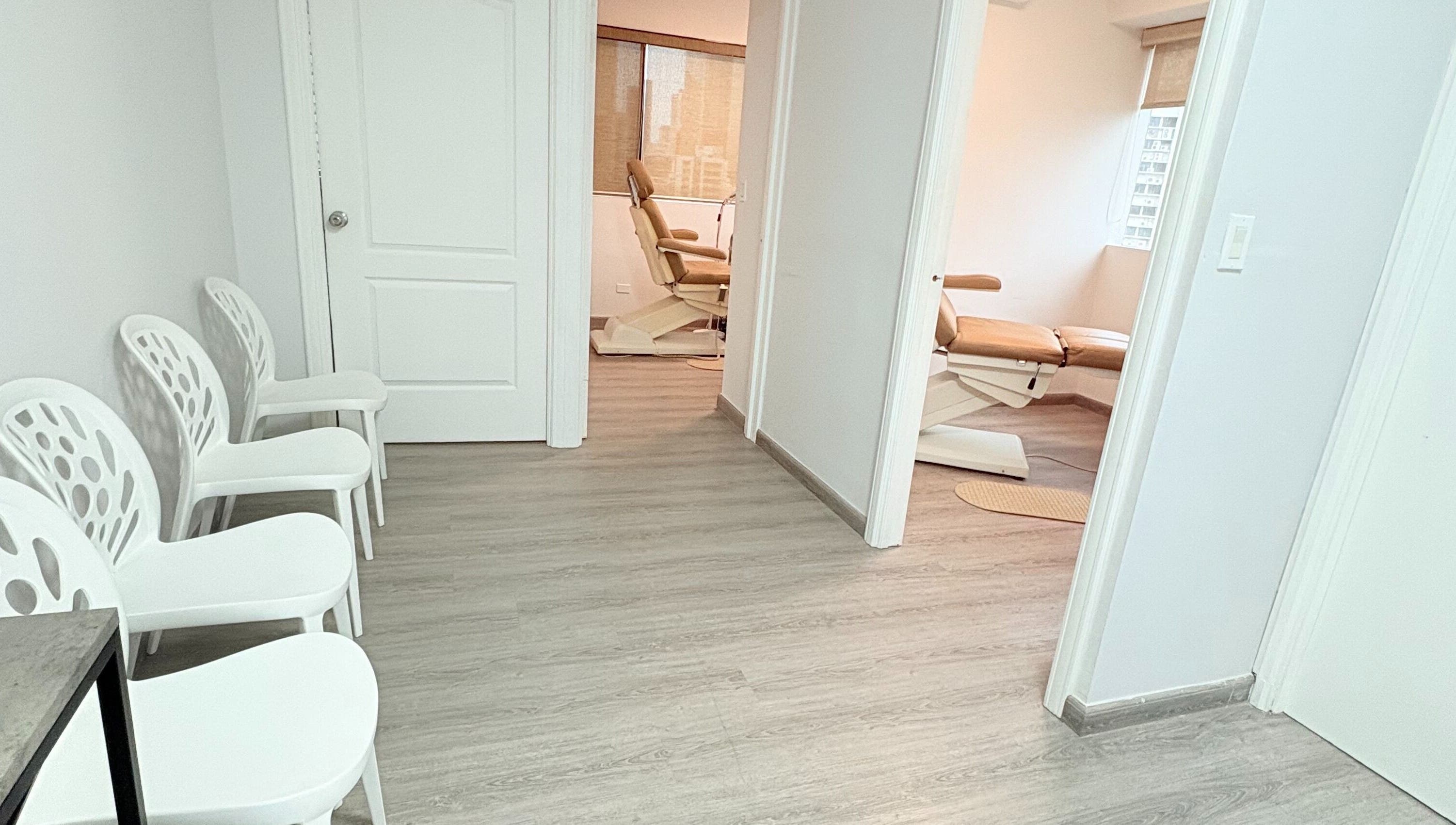 Sala de espera moderna en Quiropedia PTY Marbella, Panamá, Provincia De Panamá, PA, con sillas blancas y luz natural.