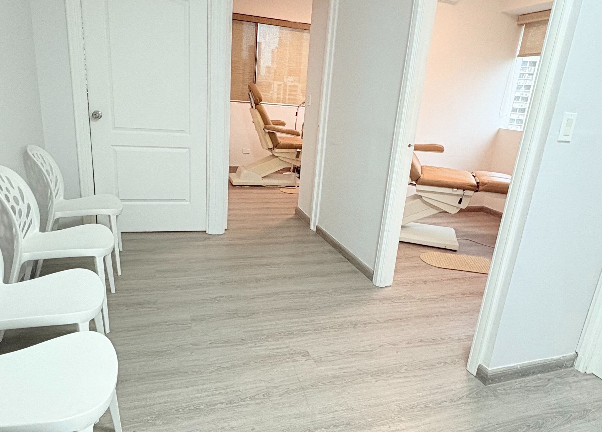 Sala de espera moderna en Quiropedia PTY Marbella, Panamá, Provincia De Panamá, PA, con sillas blancas y luz natural.