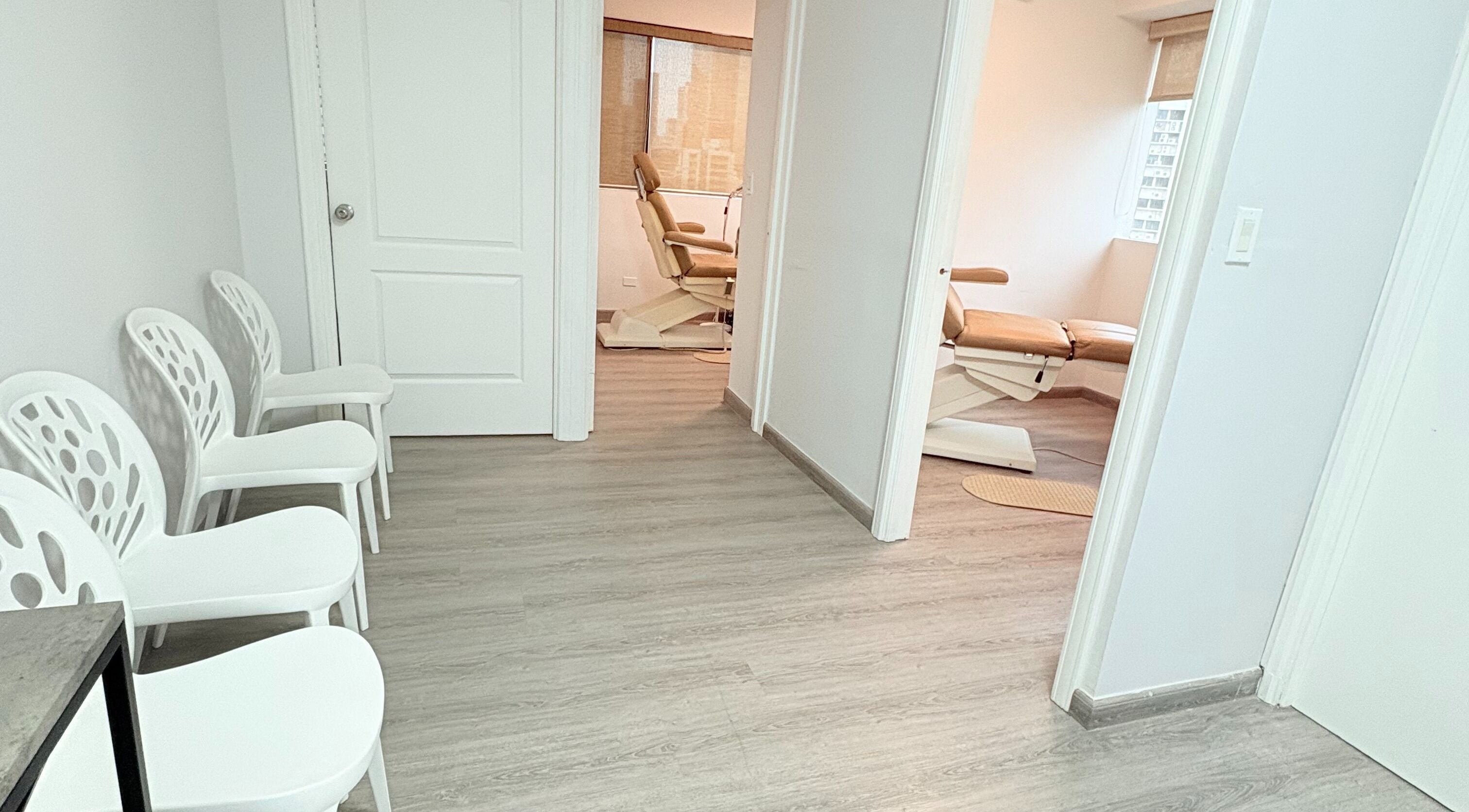 Sala de espera moderna en Quiropedia PTY Marbella, Panamá, Provincia De Panamá, PA, con sillas blancas y luz natural.