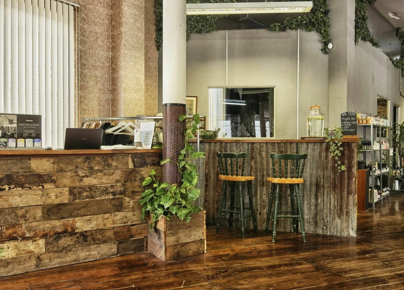 Rustic interior of The Bohemians, London, England, GB, featuring natural wood decor and greenery.
