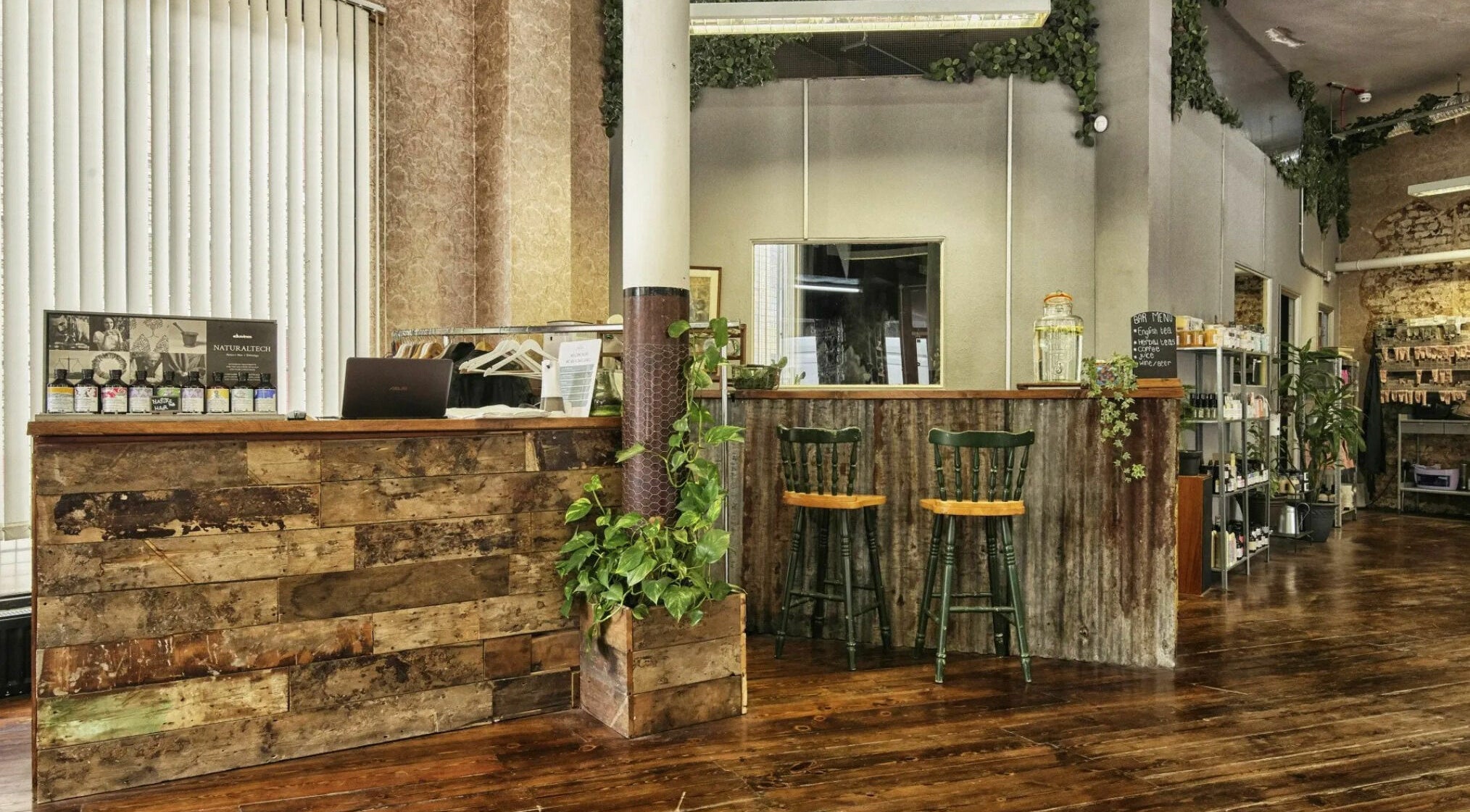 Rustic interior of The Bohemians, London, England, GB, featuring natural wood decor and greenery.