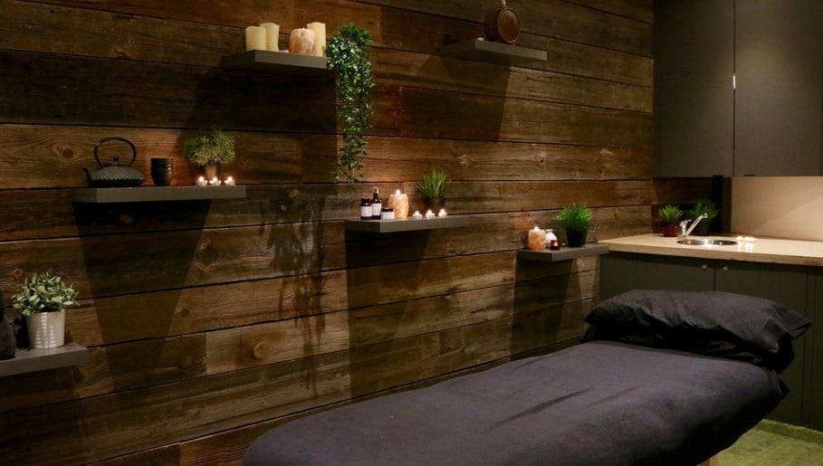 Relaxing massage room at Tian Body, Mind & Spirit Healing, London, England, GB with candles and wooden decor.