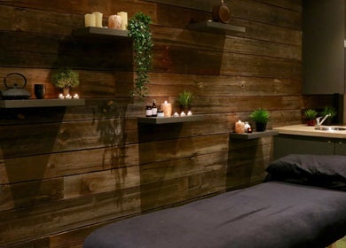 Relaxing massage room at Tian Body, Mind & Spirit Healing, London, England, GB with candles and wooden decor.