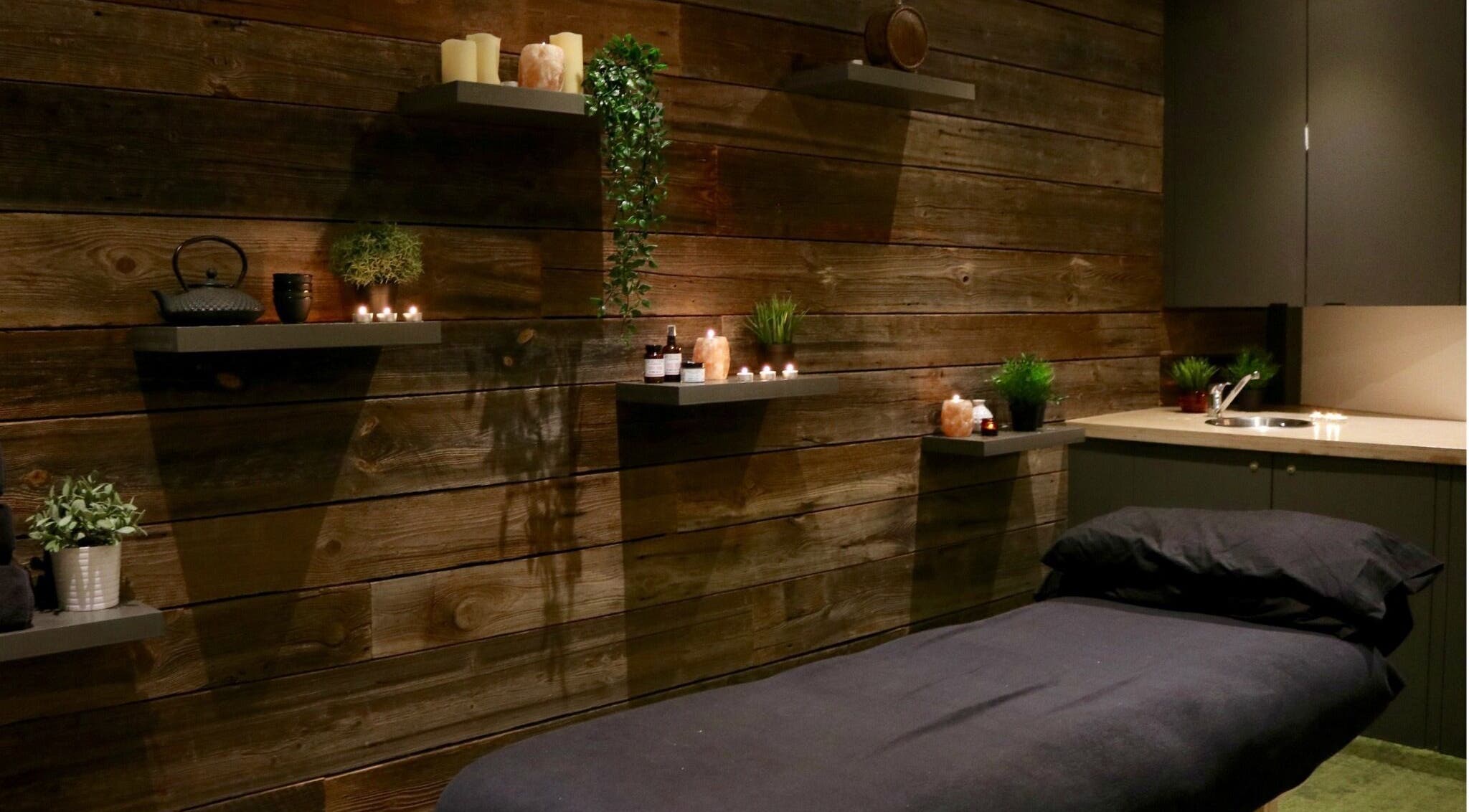Relaxing massage room at Tian Body, Mind & Spirit Healing, London, England, GB with candles and wooden decor.