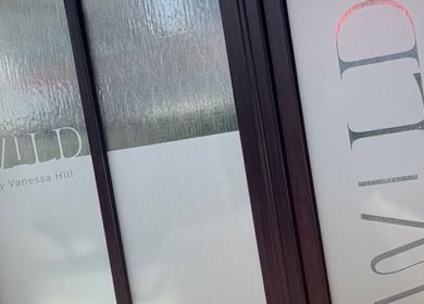 Entrance of Wild By Vanessa Hill salon in Fernhill Heath, England with glass and logo visible.
