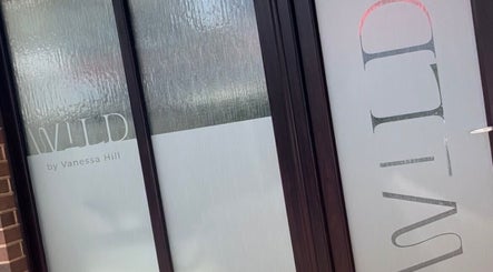 Entrance of Wild By Vanessa Hill salon in Fernhill Heath, England with glass and logo visible.