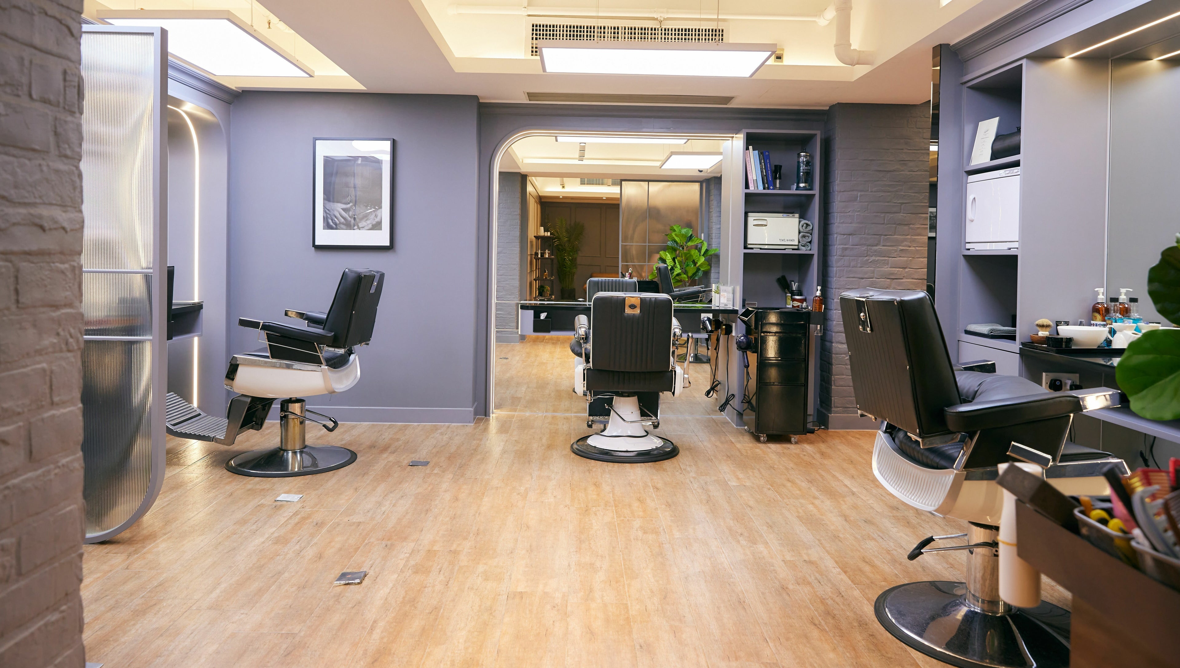 Modern interior of The Beau Barbershop & Hair Salon on Hong Kong Island, HK, featuring sleek barber chairs.