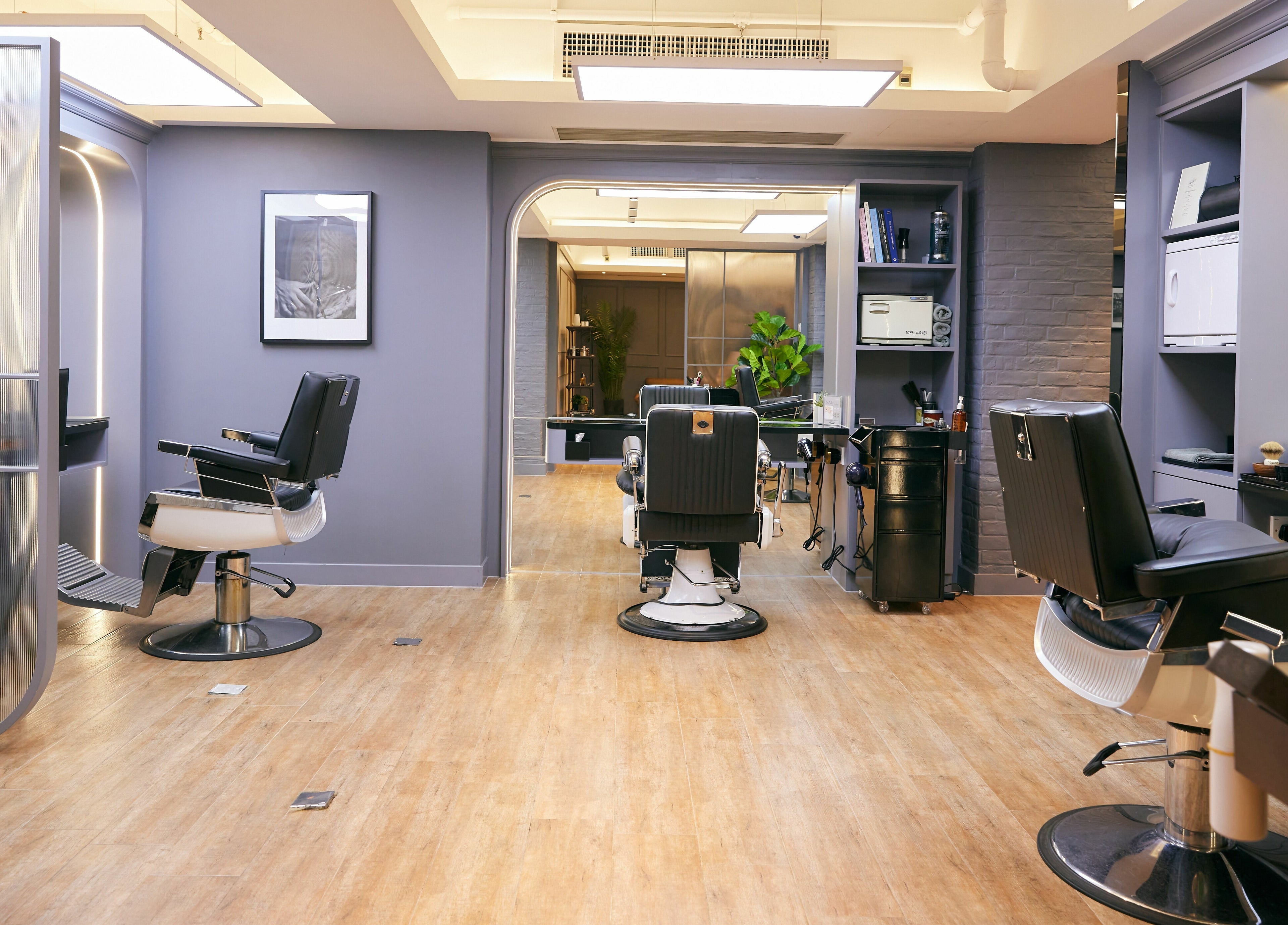 Modern interior of The Beau Barbershop & Hair Salon on Hong Kong Island, HK, featuring sleek barber chairs.