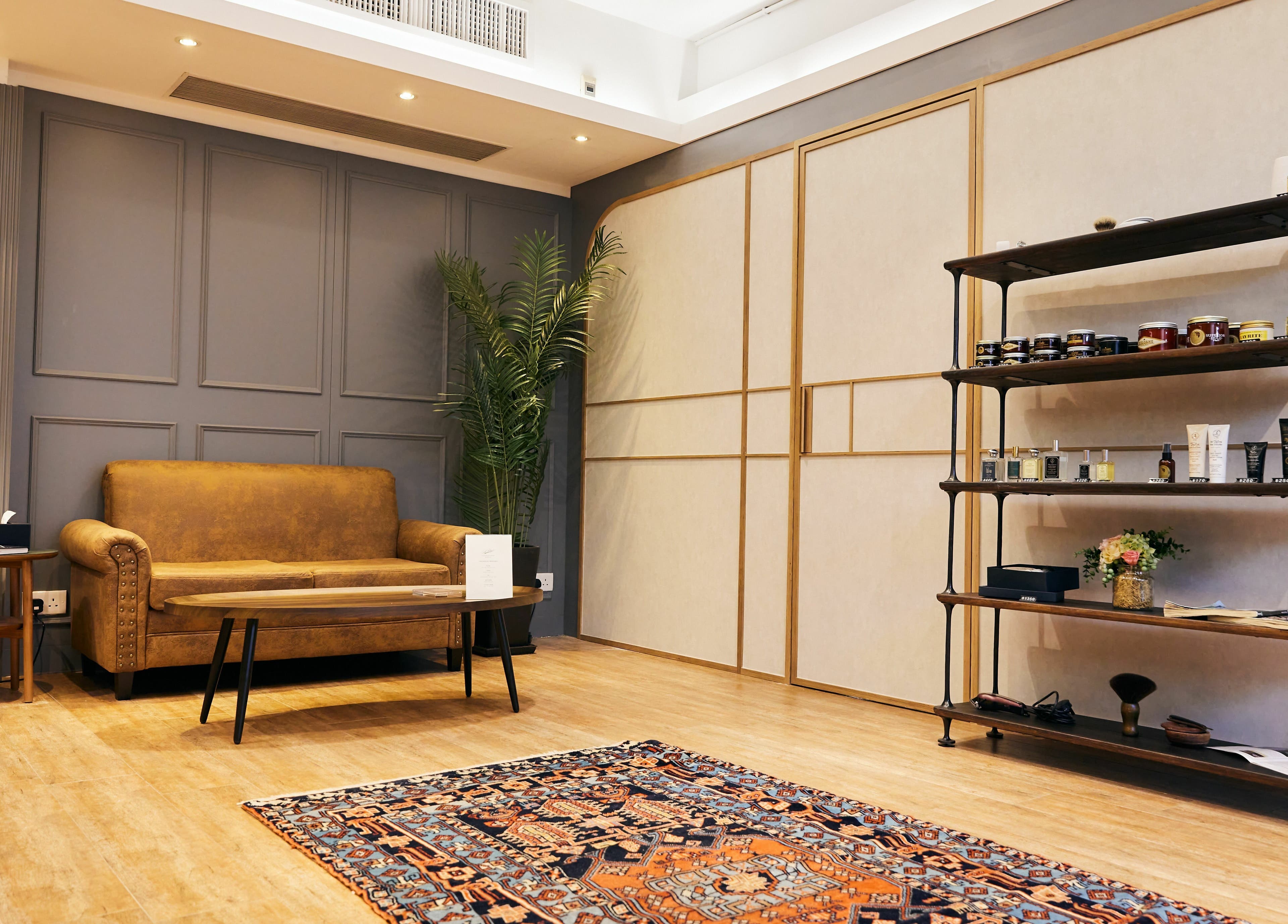 Cozy lounge area in The Beau Barbershop & Hair Salon, Hong Kong Island, with vintage sofa and decor.