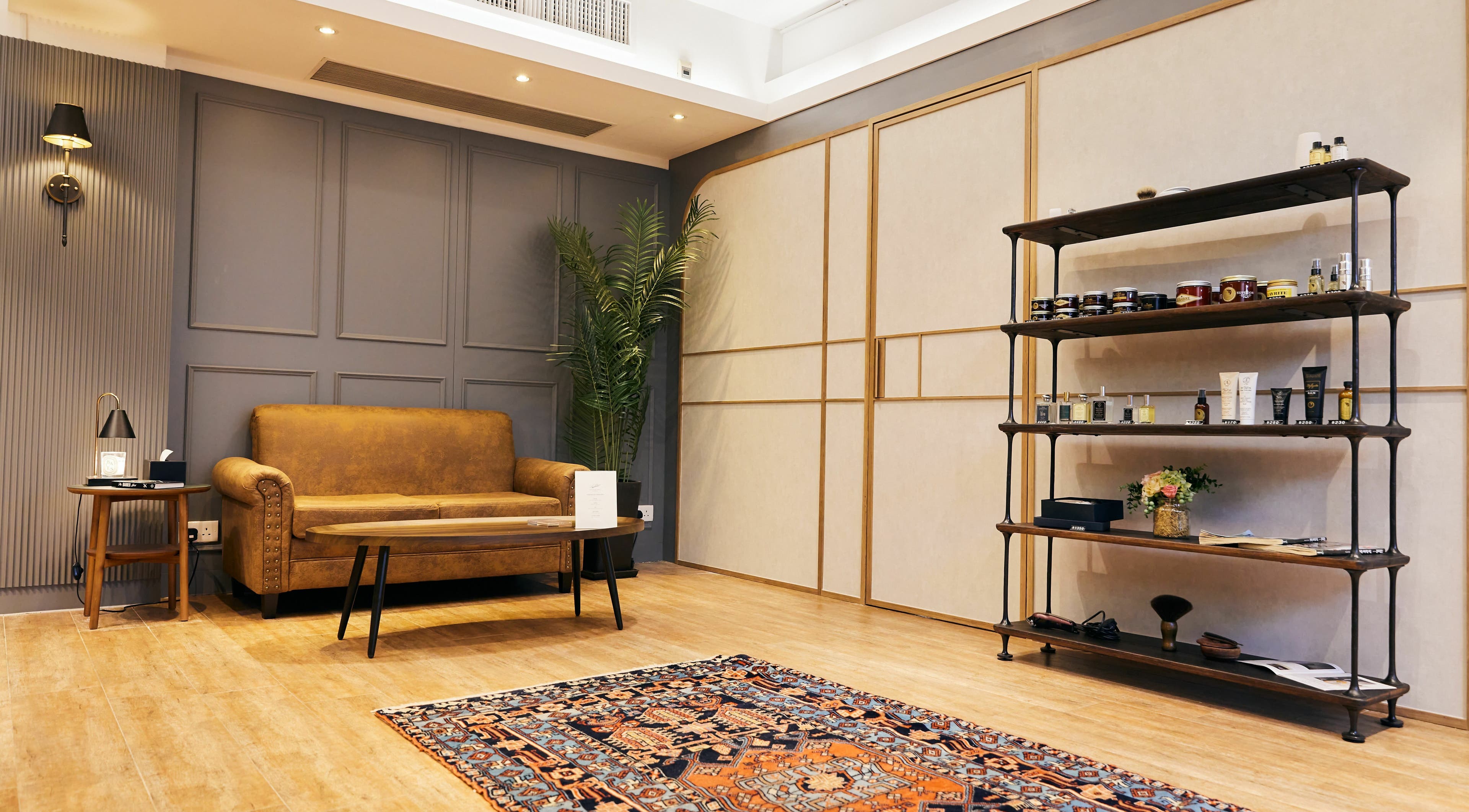 Cozy lounge area in The Beau Barbershop & Hair Salon, Hong Kong Island, with vintage sofa and decor.